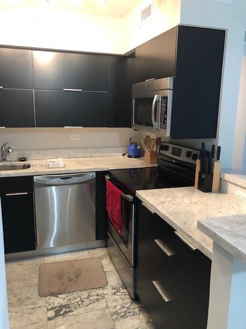 1500 Bay Road, Unit 958S Miami Beach, FL 33139 - Photo 8 of 20 a kitchen with a sink a stove top oven and cabinets