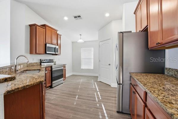 10120 Ives Loop Hudson, FL 34667 - Photo 4 of 23 a kitchen with granite countertop a sink stove and refrigerator