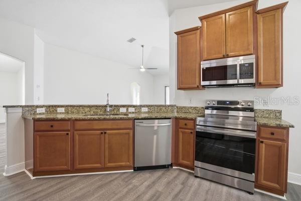 10120 Ives Loop Hudson, FL 34667 - Photo 5 of 23 a kitchen with stainless steel appliances granite countertop a stove and a microwave