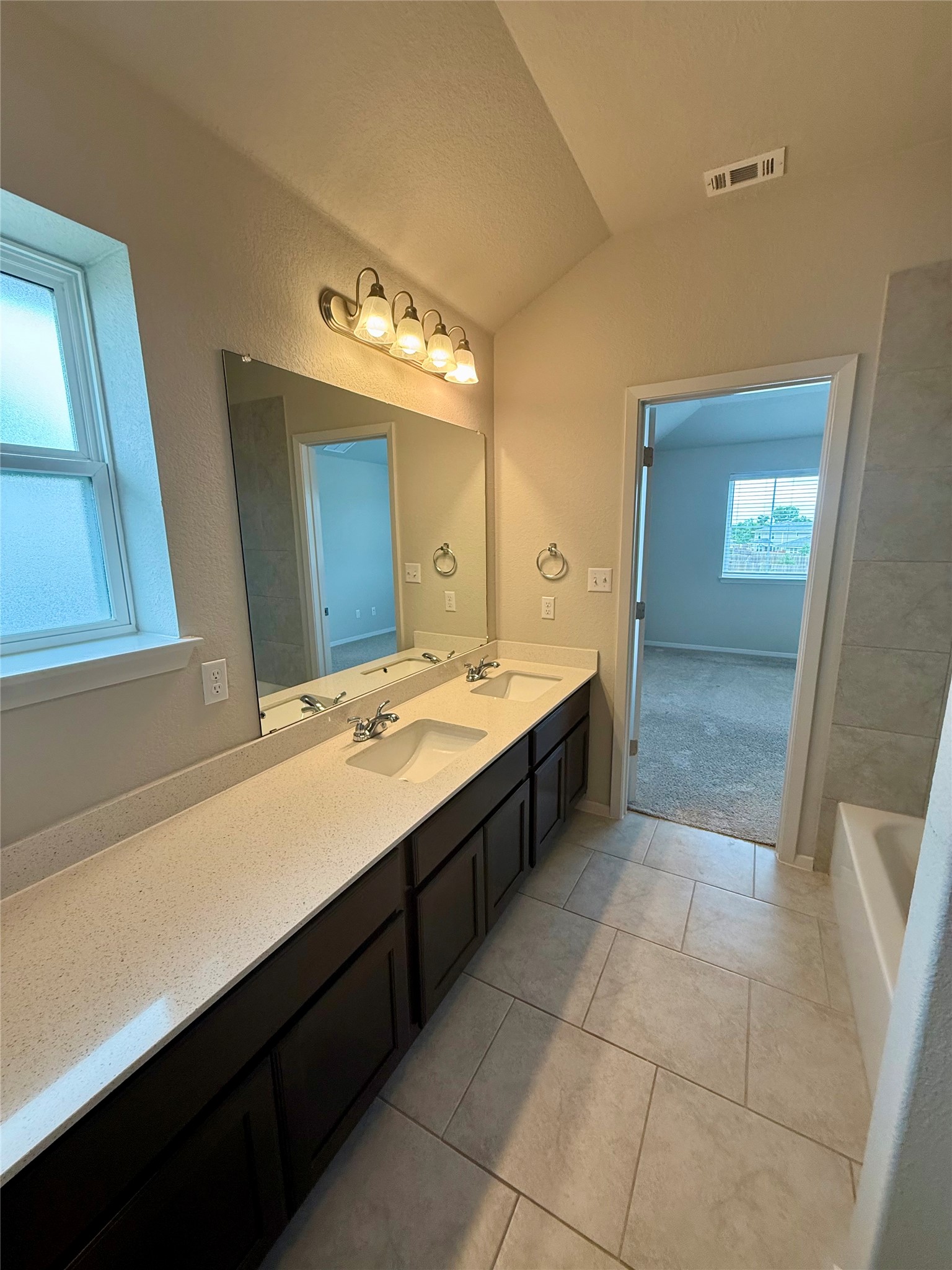 212 Lake Placid Run Elgin, TX 78621 - Photo 15 of 27 Double vanity with ample counter space and a spacious mirror defines this well-appointed primary bathroom.