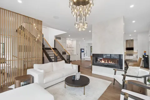 a living room with furniture a chandelier and a fireplace