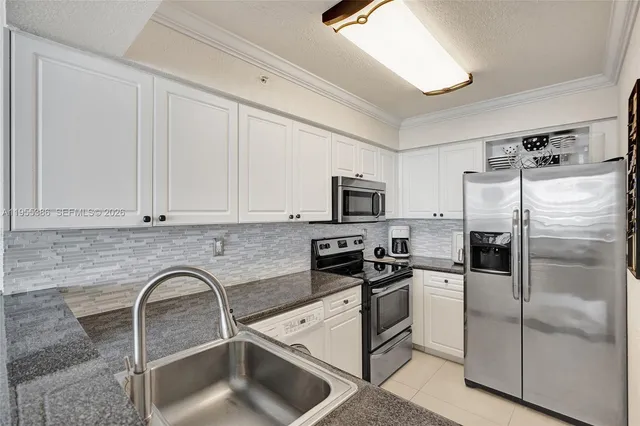a kitchen with stainless steel appliances granite countertop a refrigerator sink and stove