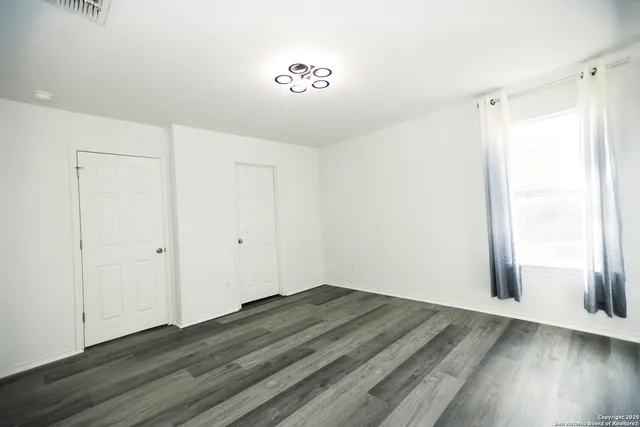 a view of a room with wooden floor and a window