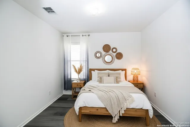 a bedroom with a bed and painting on the wall