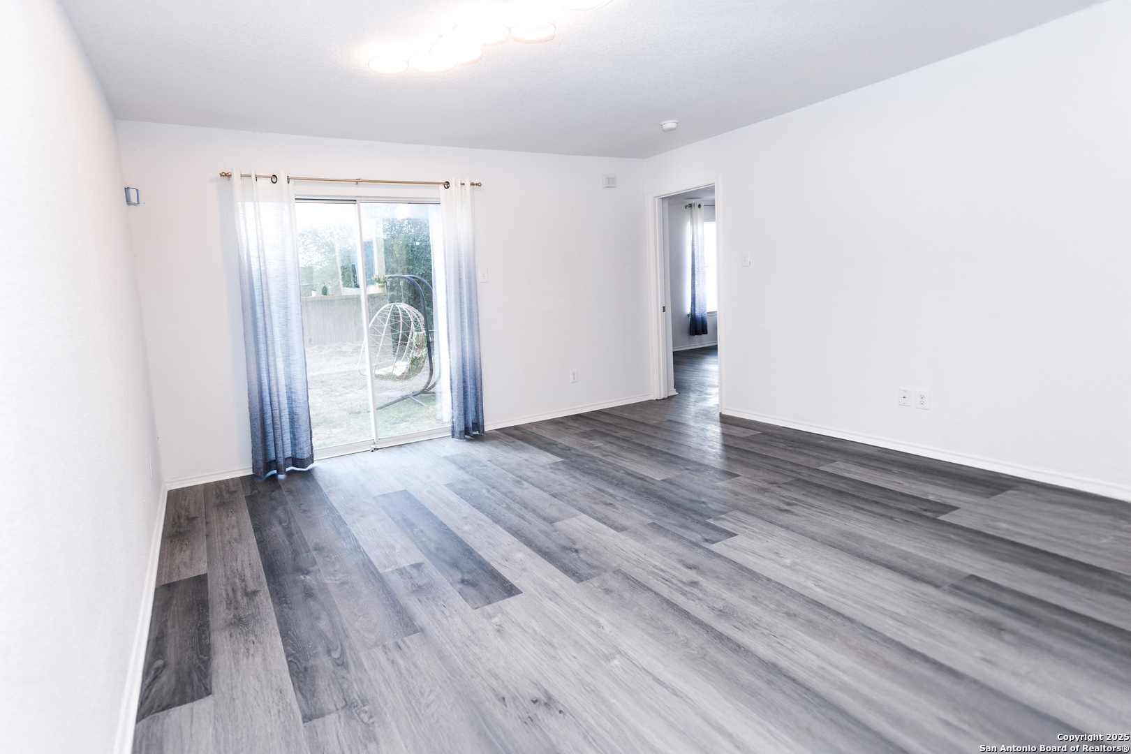2311 Cloudbait View Converse, TX 78109 - Photo 3 of 20 an empty room with wooden floor and windows