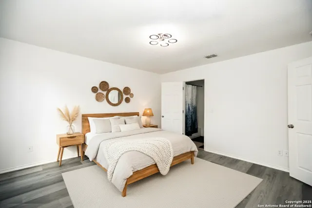 a bedroom with a bed and a lamp with wooden floor