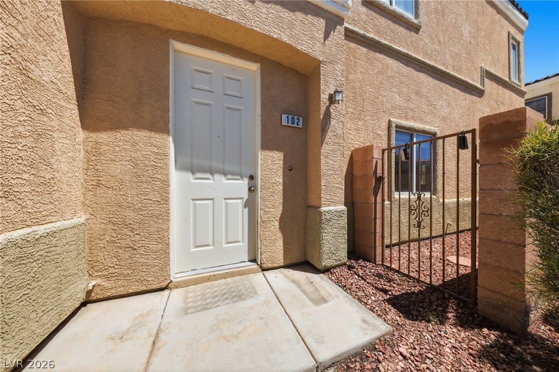 6312 Sandy Ridge Street, Unit 3102 North Las Vegas, NV 89081 - Photo 1 of 31 Secure entry via a metal gate and solid front door, framing a simple, practical pathway.