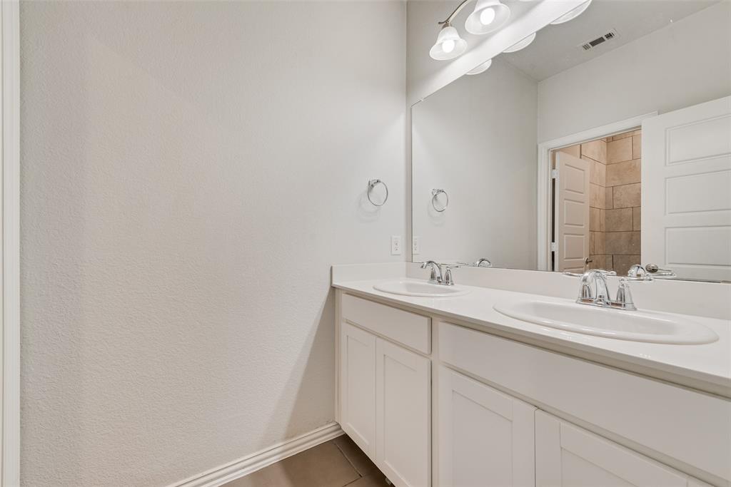 628 Ansley Way Allen, TX 75013 - Photo 16 of 20 Dual vanity with white cabinetry and integrated sinks, chrome fixtures, and a large wall-mounted mirror