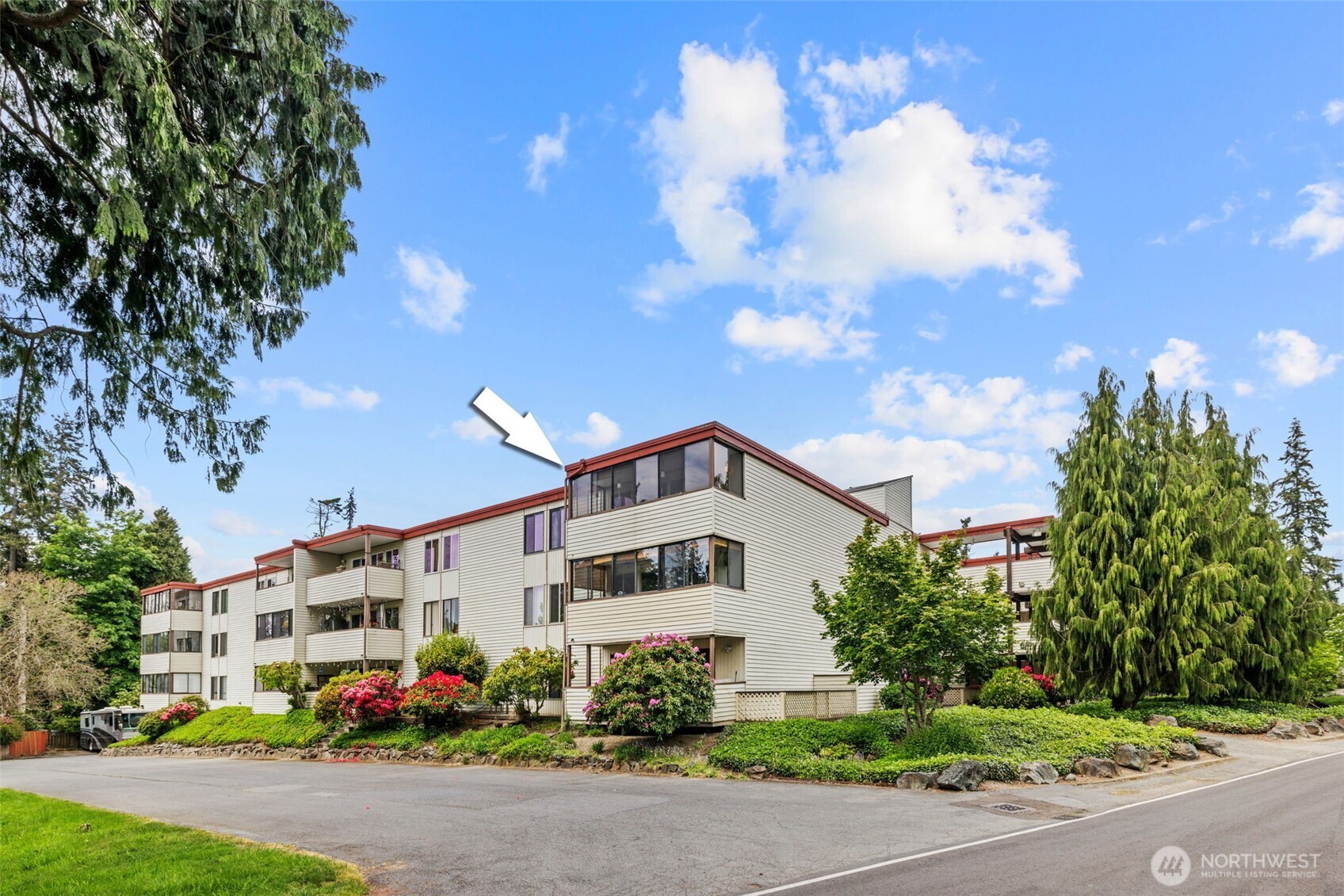 a view of a white house with a yard and garden