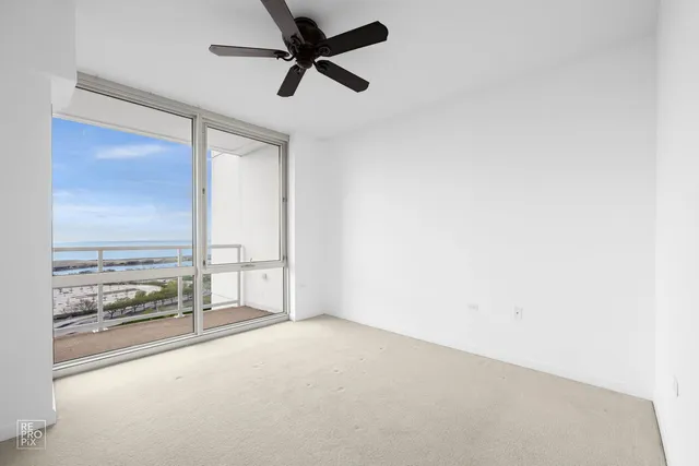 an empty room with fan and windows