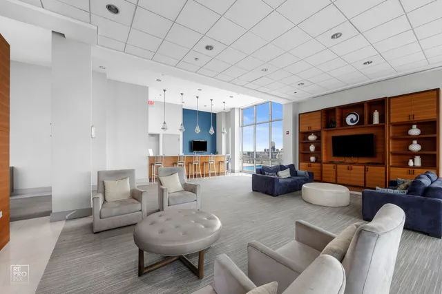 a living room with furniture a flat screen tv and kitchen view
