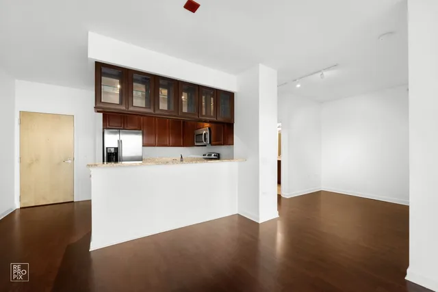 a view of kitchen with hallway and wooden floor