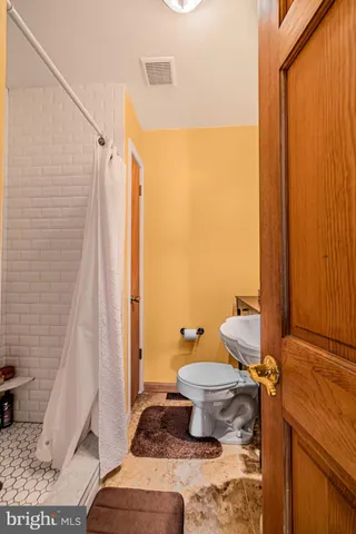 a bathroom with a toilet and a shower