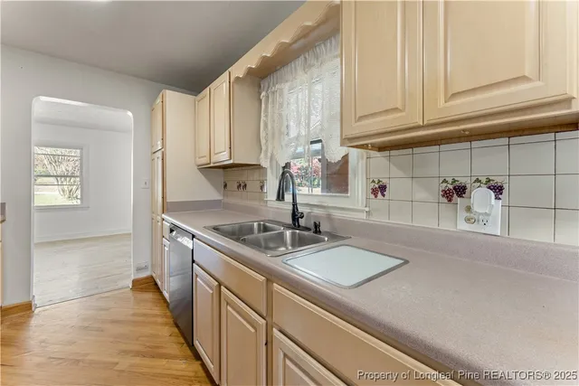 a kitchen with stainless steel appliances granite countertop a sink and a white cabinets