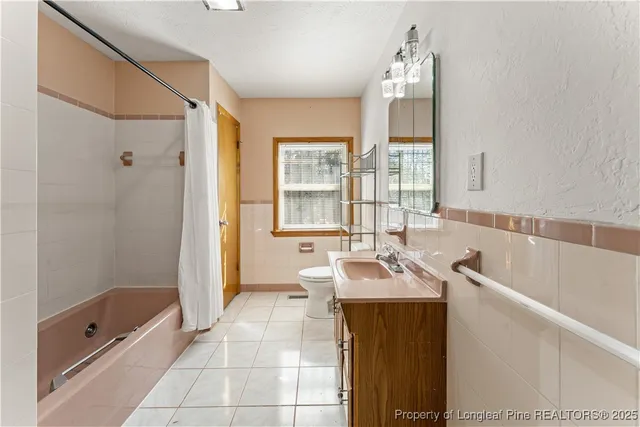 a spacious bathroom with a tub sink and mirror