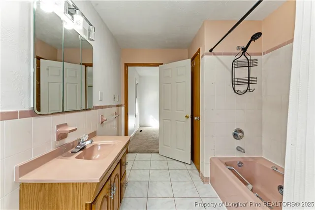 a bathroom with a tub sink and mirror