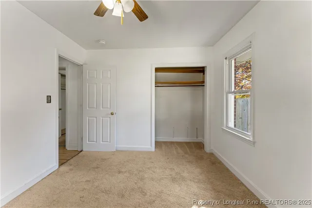 an empty room with closet and windows
