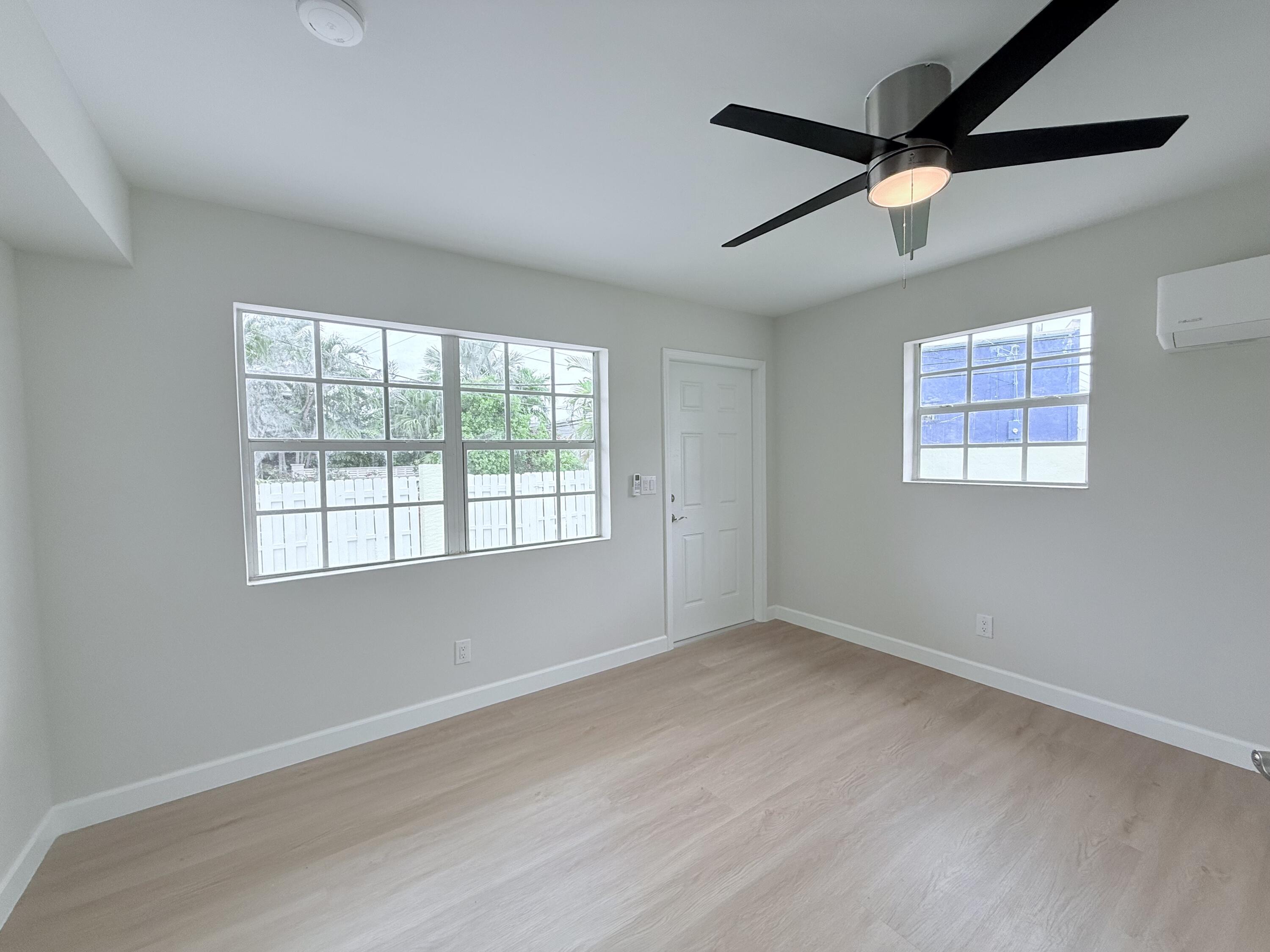 2401 Patterson Avenue, Unit 101 Key West, FL 33040 - Photo 15 of 26 an empty room with wooden floor fan and windows