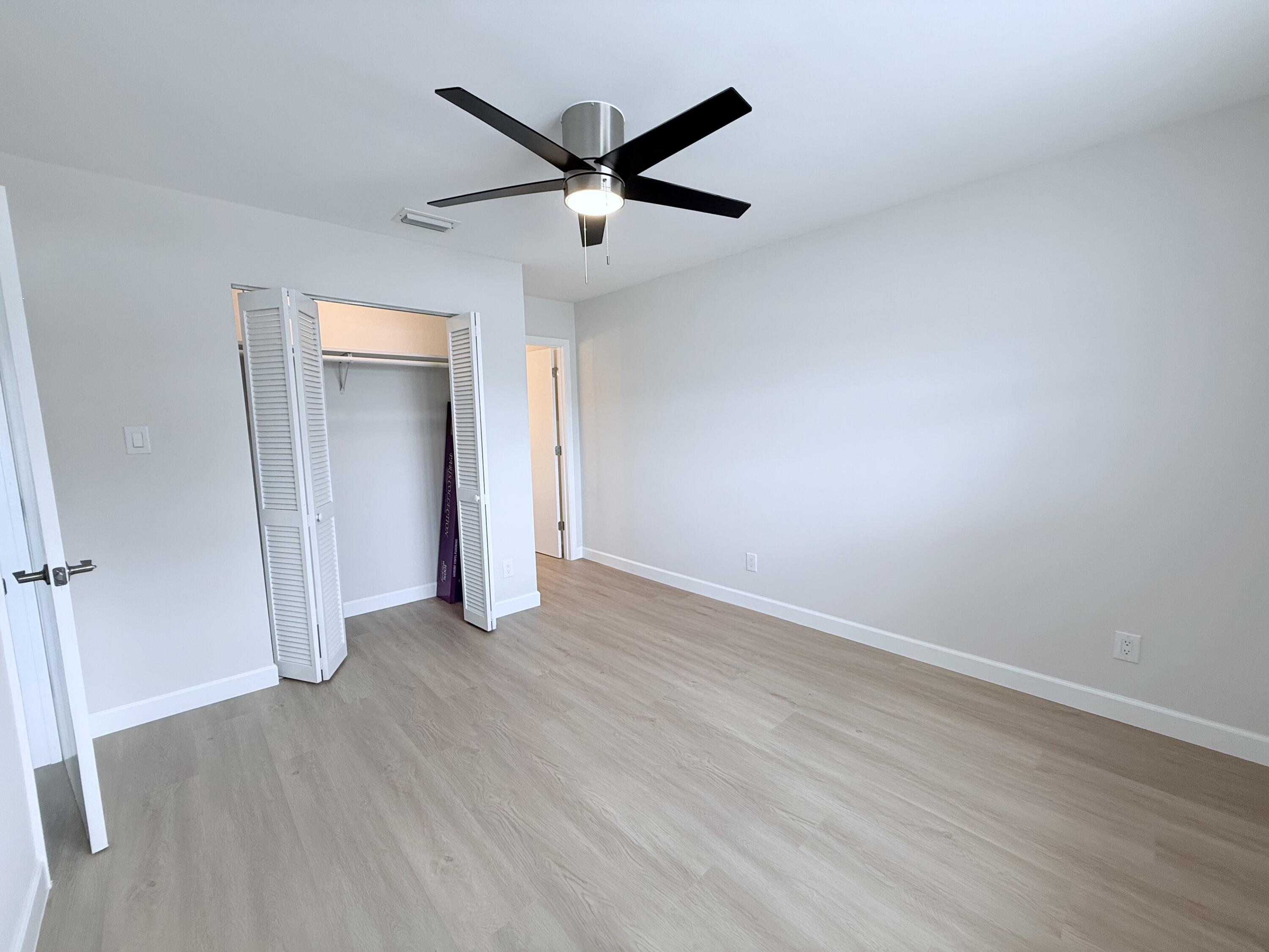 2401 Patterson Avenue, Unit 101 Key West, FL 33040 - Photo 6 of 26 an empty room with wooden floor and a ceiling fan
