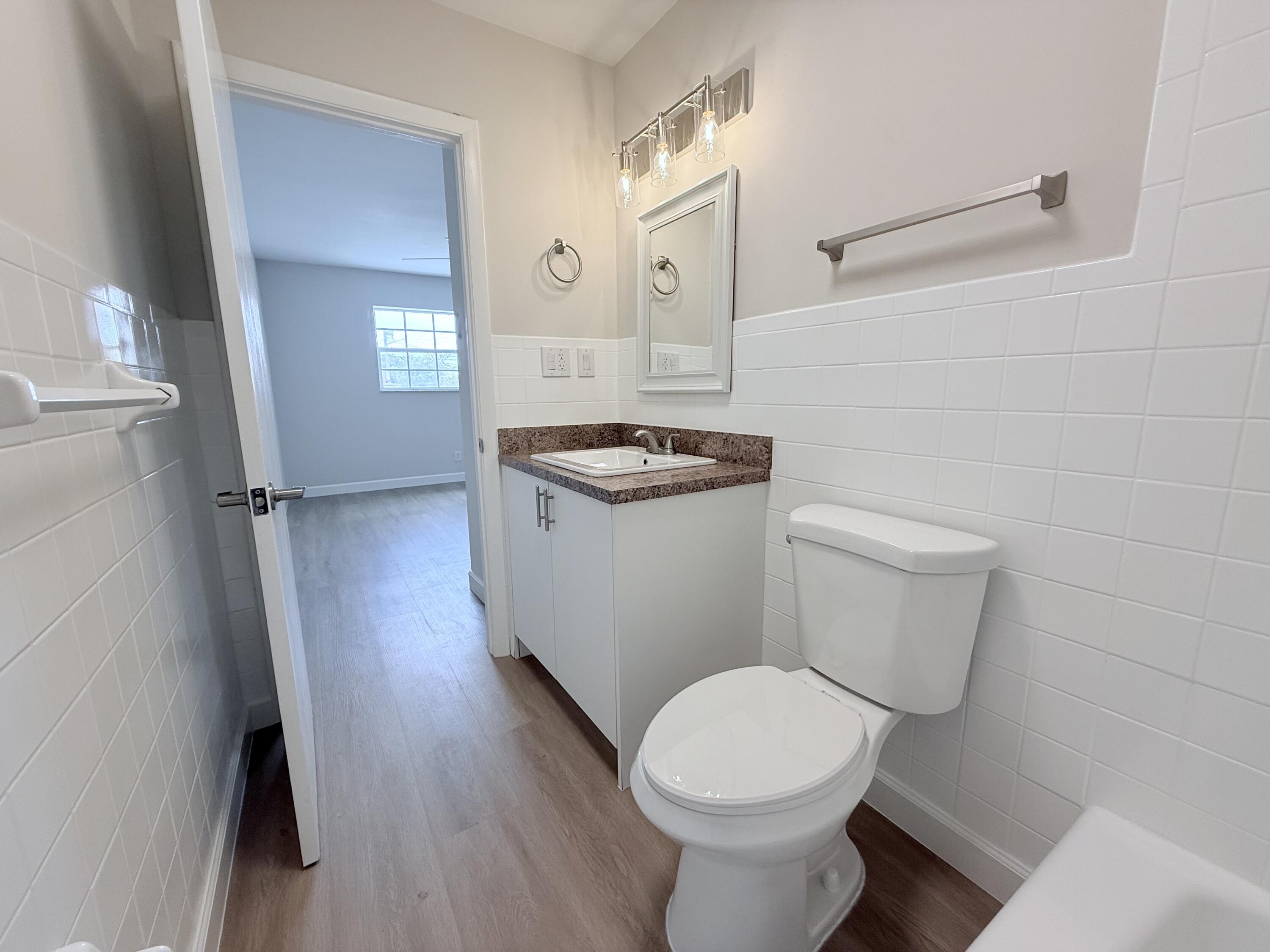 2401 Patterson Avenue, Unit 101 Key West, FL 33040 - Photo 9 of 26 a bathroom with a sink a toilet a window and vanity