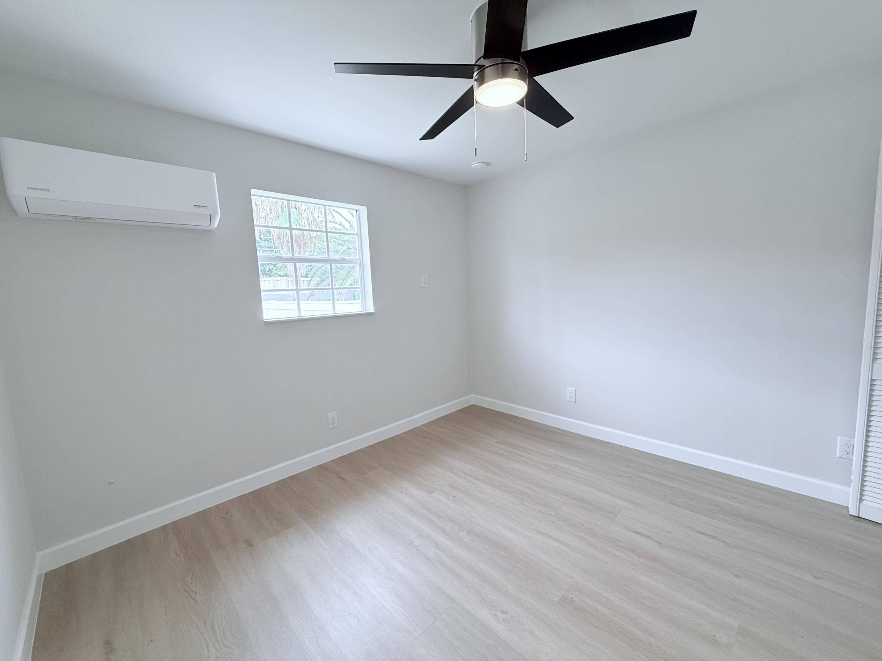 2401 Patterson Avenue, Unit 101 Key West, FL 33040 - Photo 10 of 26 an empty room with wooden floor ceiling fan and windows