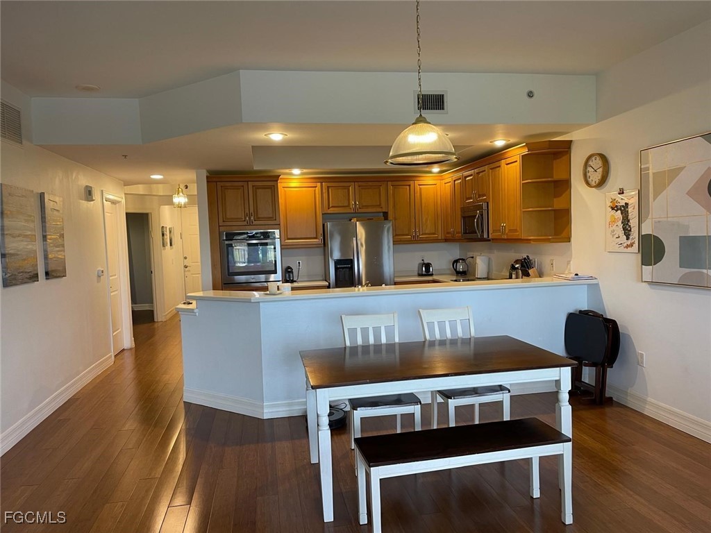 14380 Riva Del Lago Drive, Unit 1002 Fort Myers, FL 33907 - Photo 3 of 23 a kitchen with a dining table chairs and a wooden floor