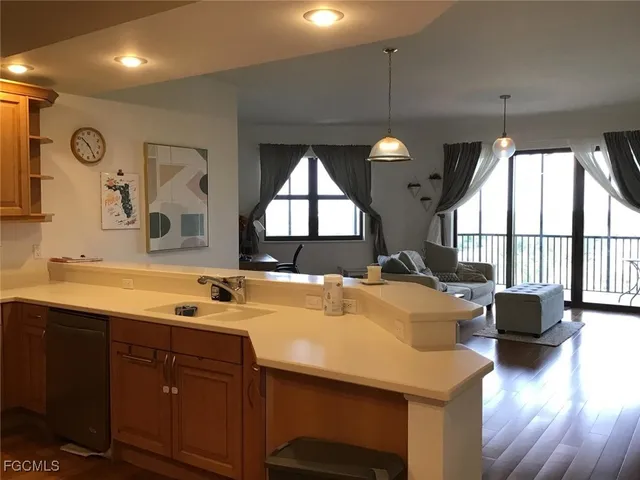 a dining hall with stainless steel appliances granite countertop a sink a stove and a wooden floors