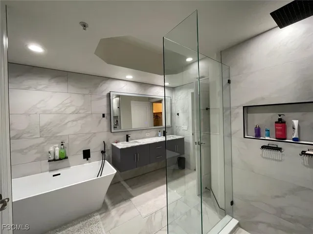 a bathroom with a tub a sink and a shower