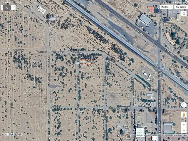 a view of a dry field with lots of trees
