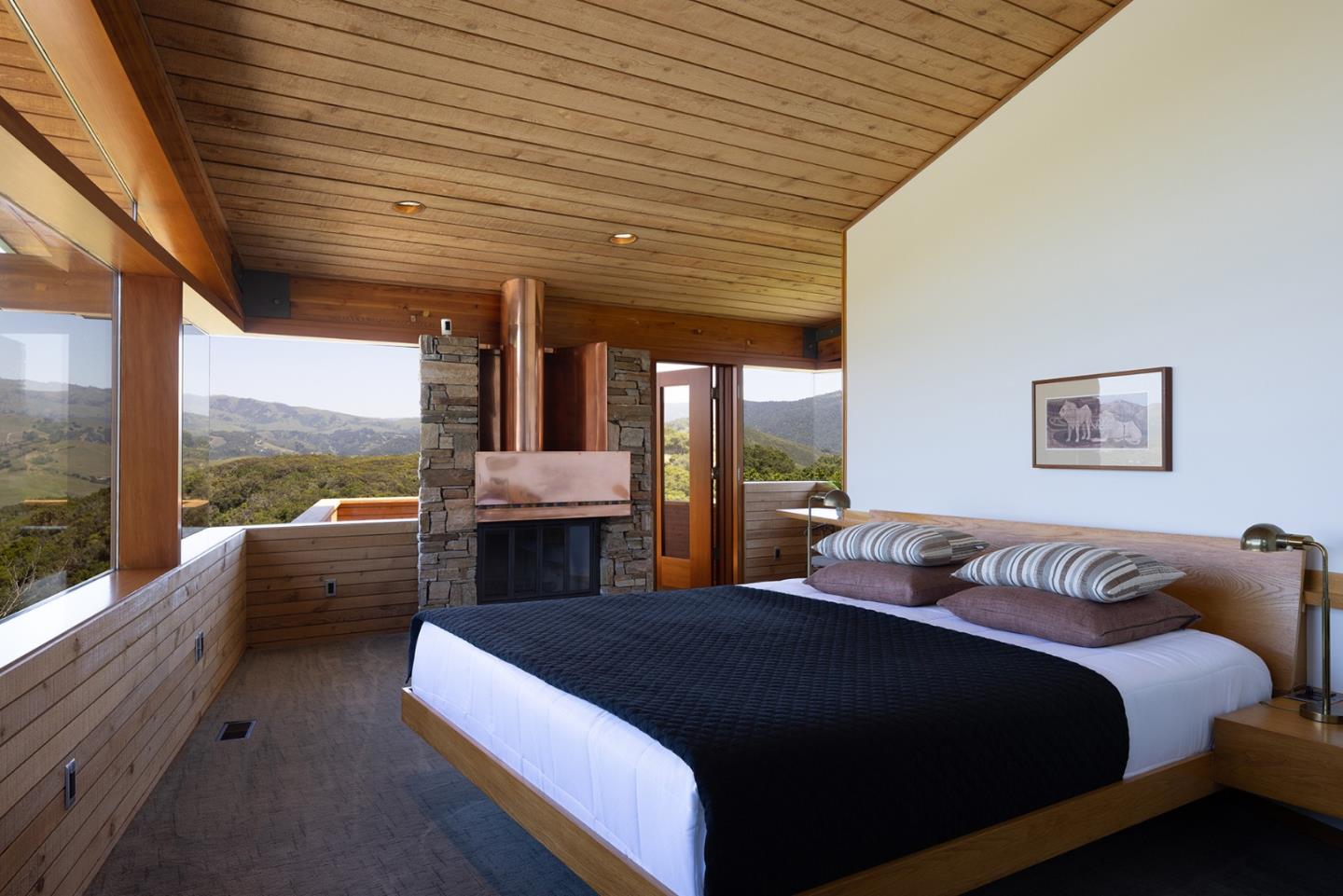26225 Rinconada Drive Carmel Valley, CA 93924 - Photo 23 of 44 a spacious bedroom with a large bed and a large window
