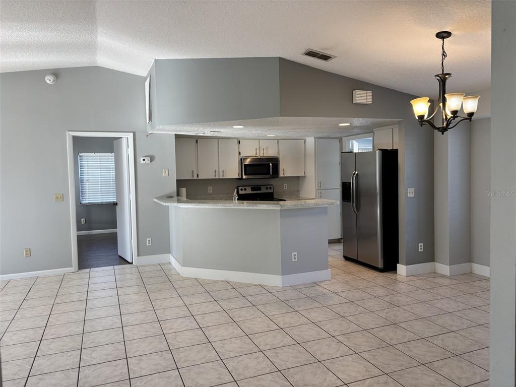 1927 Cheney Court Lutz, FL 33549 - Photo 4 of 20 a kitchen with stainless steel appliances kitchen island granite countertop a refrigerator and a sink