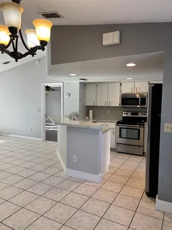 a kitchen with stainless steel appliances kitchen island granite countertop a refrigerator and a stove top oven