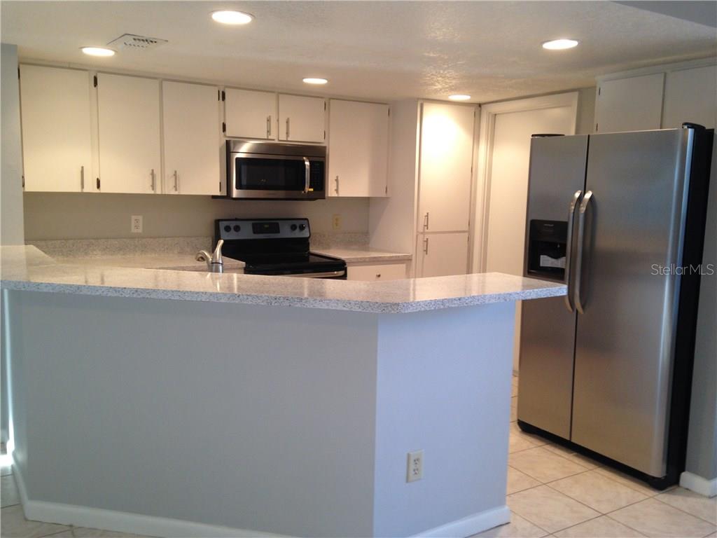 1927 Cheney Court Lutz, FL 33549 - Photo 7 of 20 a kitchen with stainless steel appliances granite countertop a refrigerator and a stove