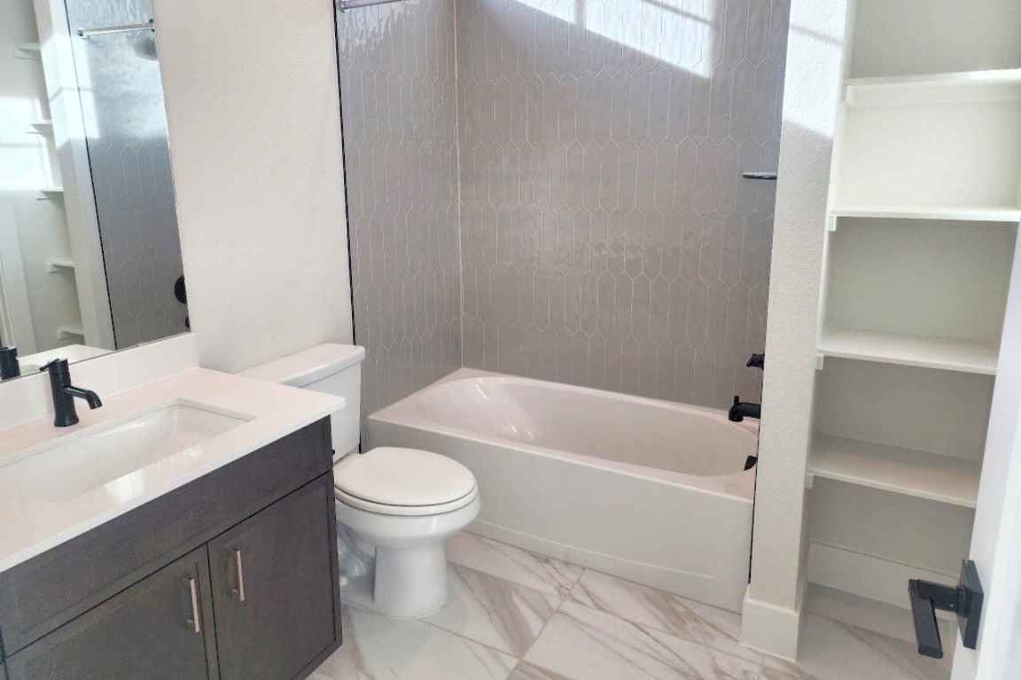 1400 Paxton Lane Georgetown, TX 78633 - Photo 11 of 39 Full bathroom featuring vanity, shower combination, and light marble finish floors