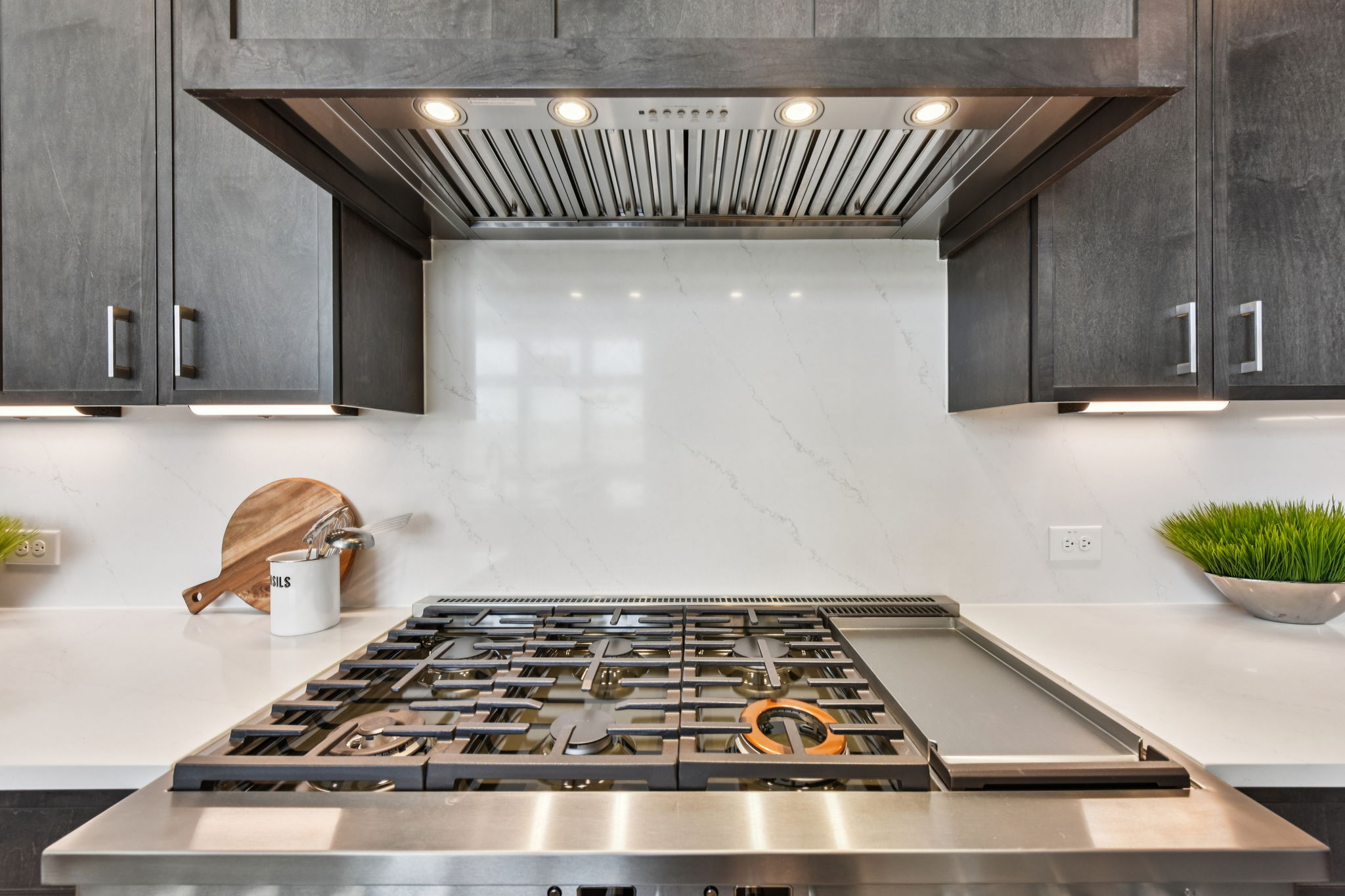 1400 Paxton Lane Georgetown, TX 78633 - Photo 13 of 39 Kitchen featuring ventilation hood, decorative backsplash, stainless steel gas cooktop, and light stone countertops