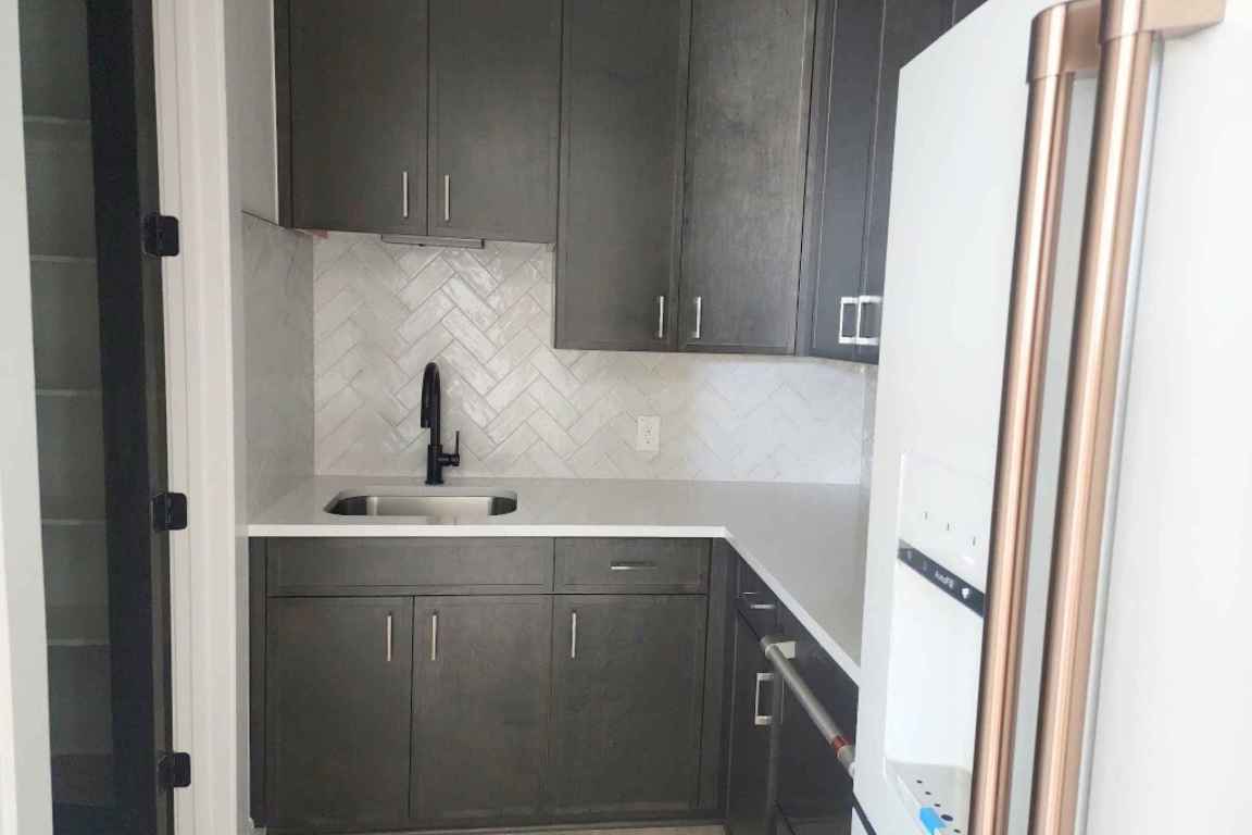 1400 Paxton Lane Georgetown, TX 78633 - Photo 5 of 39 Kitchen featuring fridge, tasteful backsplash, dark brown cabinetry, and light stone countertops