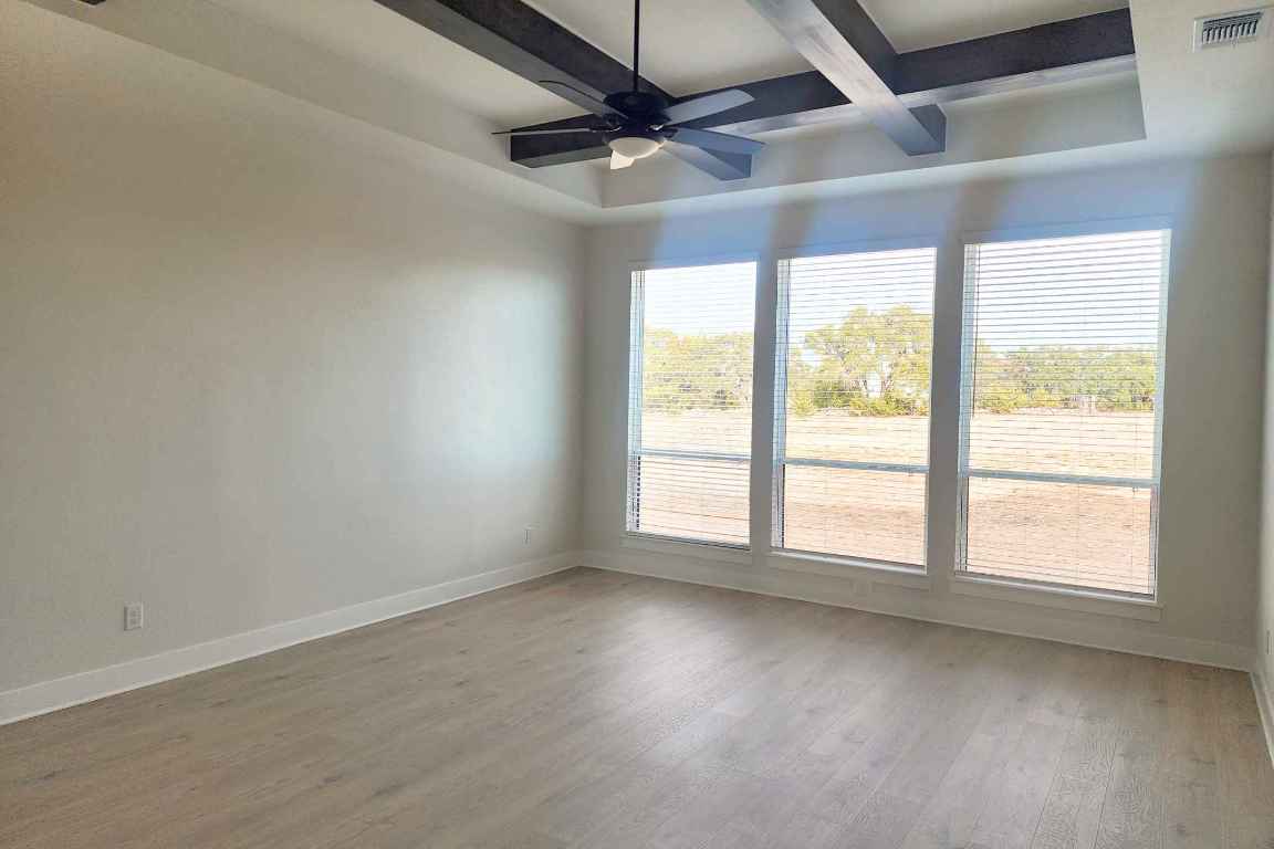 1400 Paxton Lane Georgetown, TX 78633 - Photo 8 of 39 Unfurnished room with light wood-style floors, beamed ceiling, ceiling fan, and coffered ceiling