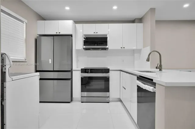 a kitchen with stainless steel appliances a refrigerator sink and white cabinets