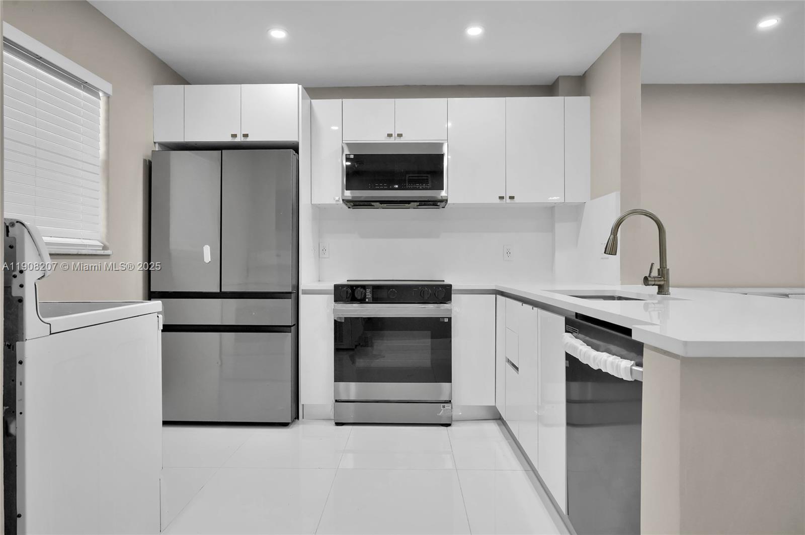 a kitchen with stainless steel appliances a refrigerator sink and white cabinets
