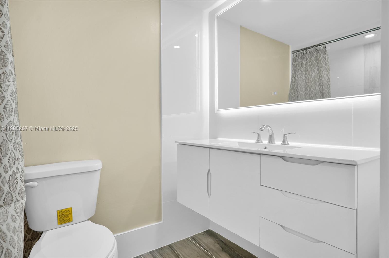 100 Ashbury Road, Unit 103 Hollywood, FL 33024 - Photo 11 of 28 a bathroom with a sink mirror vanity and toilet