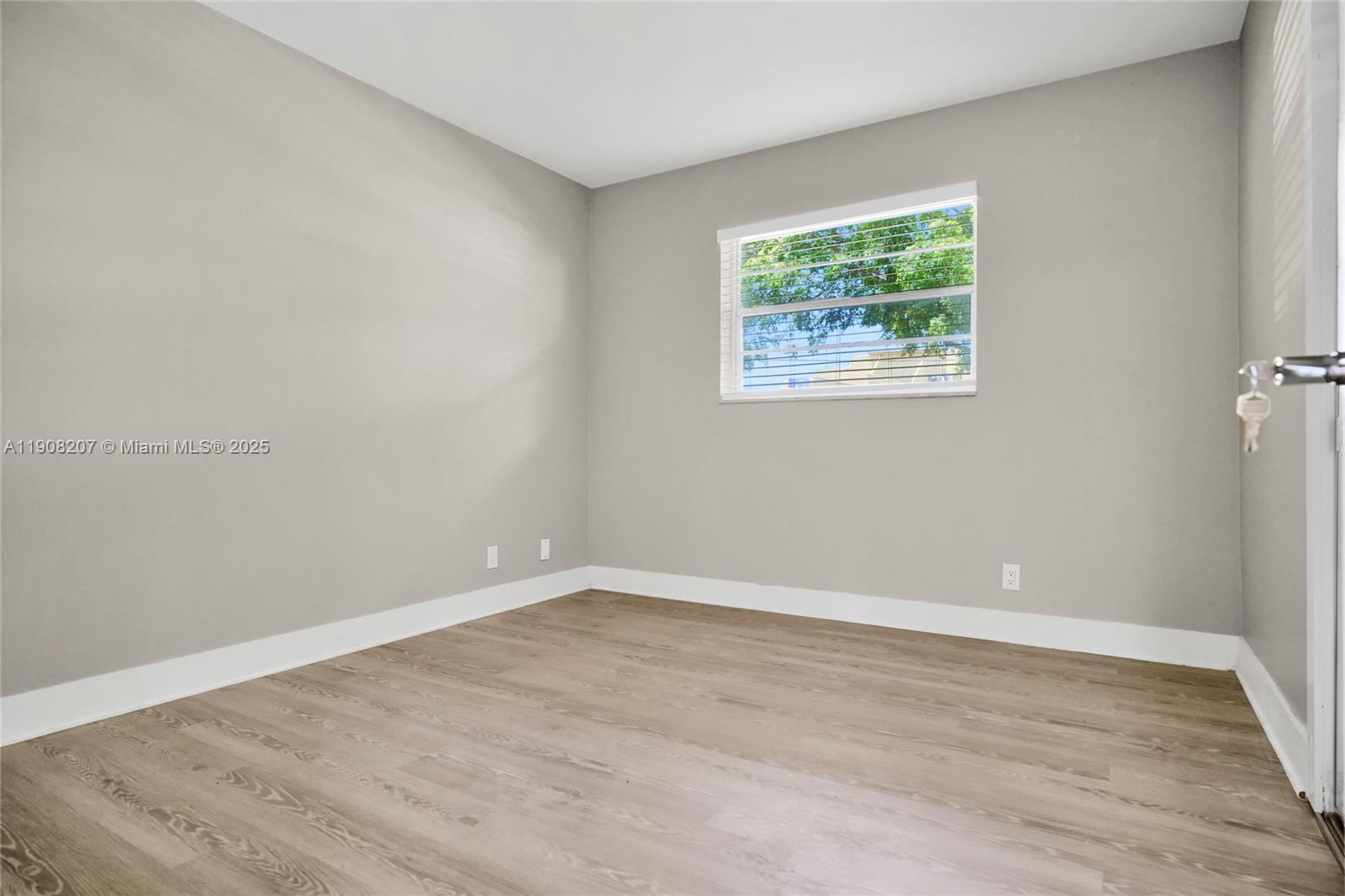100 Ashbury Road, Unit 103 Hollywood, FL 33024 - Photo 13 of 28 a view of an empty room with wooden floor and a window