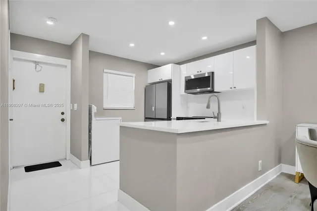 a kitchen with stainless steel appliances a refrigerator and a stove top oven