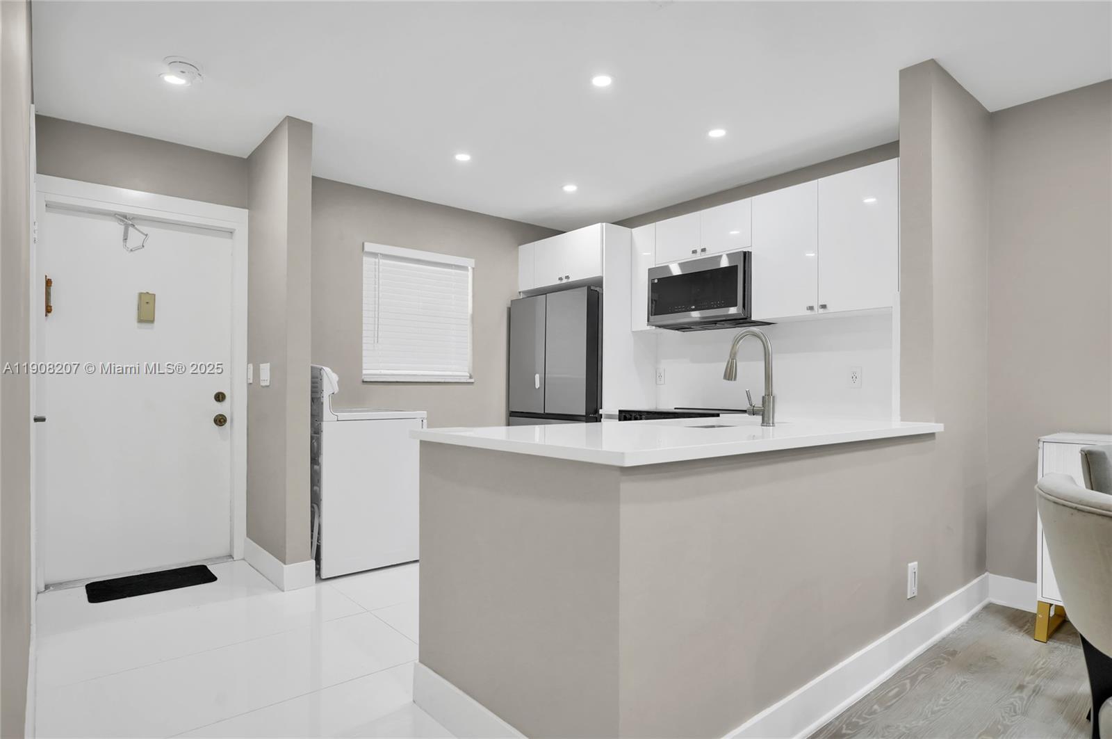 100 Ashbury Road, Unit 103 Hollywood, FL 33024 - Photo 2 of 28 a kitchen with stainless steel appliances a refrigerator and a stove top oven