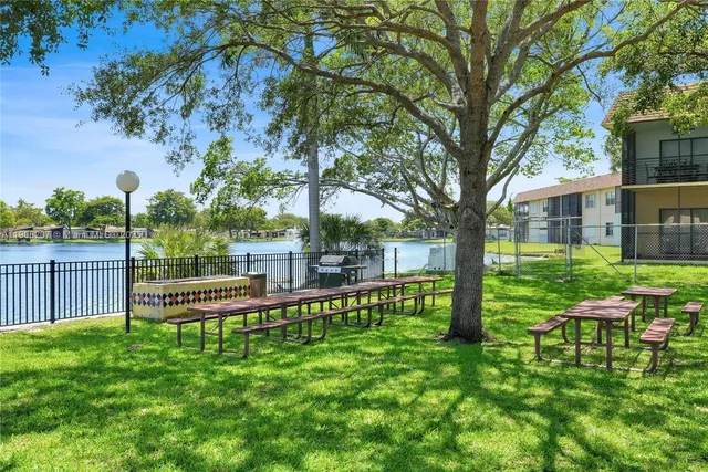 a view of a house with a backyard and a large tree