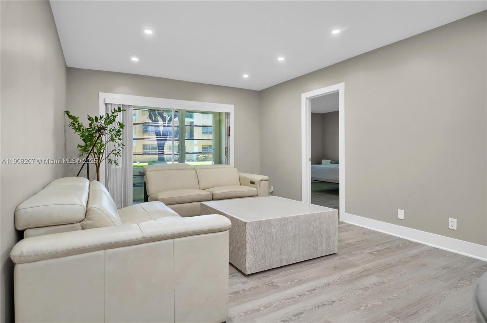 100 Ashbury Road, Unit 103 Hollywood, FL 33024 - Photo 4 of 28 a living room with furniture and a potted plant