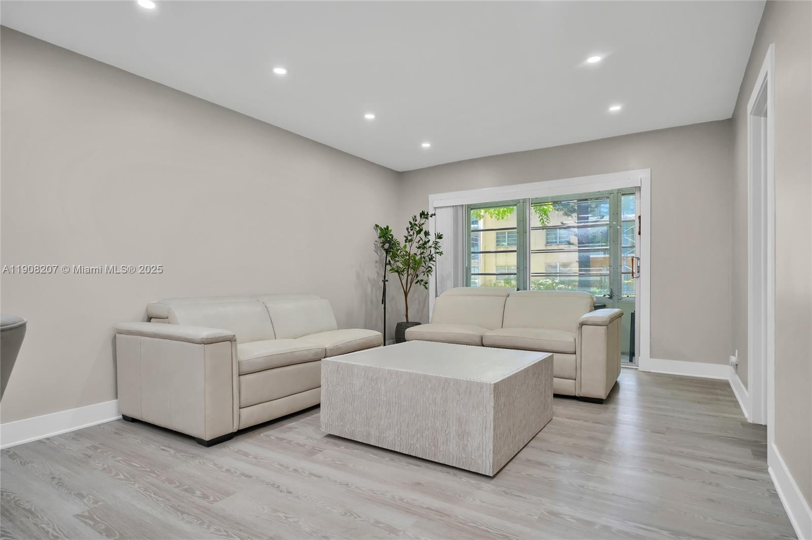 100 Ashbury Road, Unit 103 Hollywood, FL 33024 - Photo 6 of 28 a living room with furniture and a large window