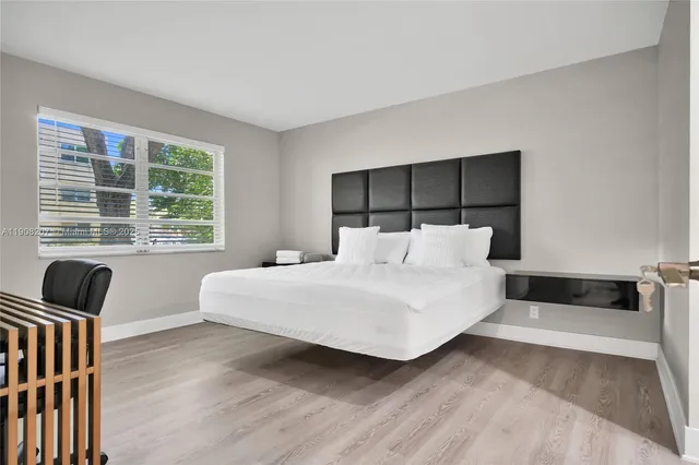 a bedroom with a bed and wooden floor