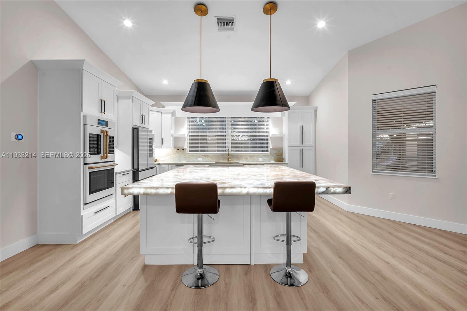 17844 38th Road North Loxahatchee, FL 33470 - Photo 11 of 66 a kitchen with stainless steel appliances kitchen island granite countertop a stove and a wooden floor