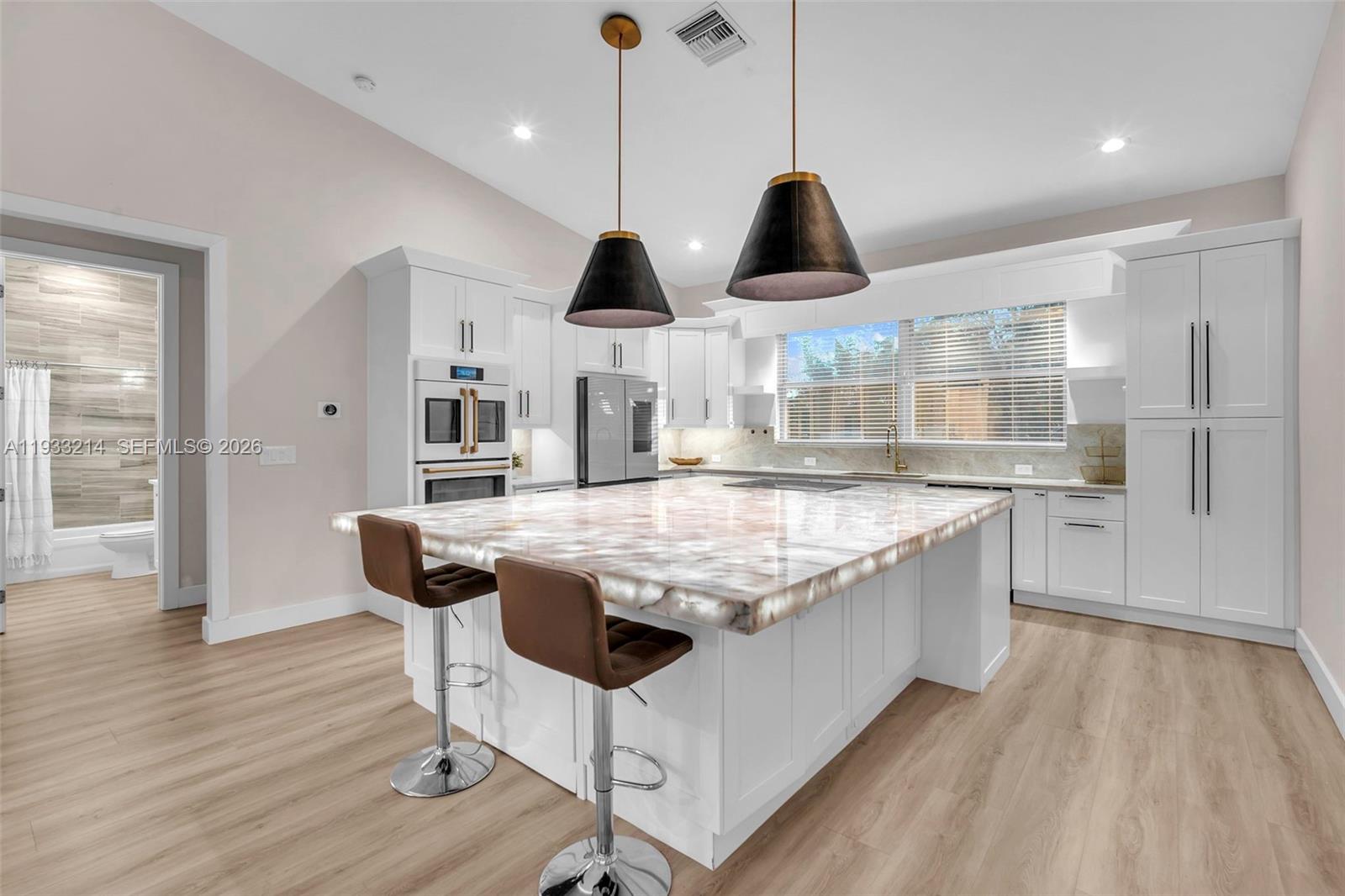 17844 38th Road North Loxahatchee, FL 33470 - Photo 12 of 66 a kitchen with stainless steel appliances granite countertop wooden floors and a view of living room