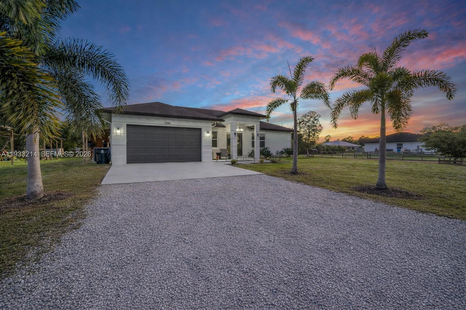 17844 38th Road North Loxahatchee, FL 33470 - Photo 56 of 66 front view of house with a yard and palm trees